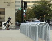 A lone cyclist waits for a traffic signal near empty bicycle racks in the Federal Center Plaza area during day three of the U.S. government shutdown in Washington October 3, 2013. President Barack Obama met with Republican and Democratic leaders in Congress on Wednesday to try to break a budget deadlock that has shut wide swaths of the federal government, but there was no breakthrough and both sides blamed each other. REUTERS/Gary Cameron (UNITED STATES - Tags: POLITICS BUSINESS)