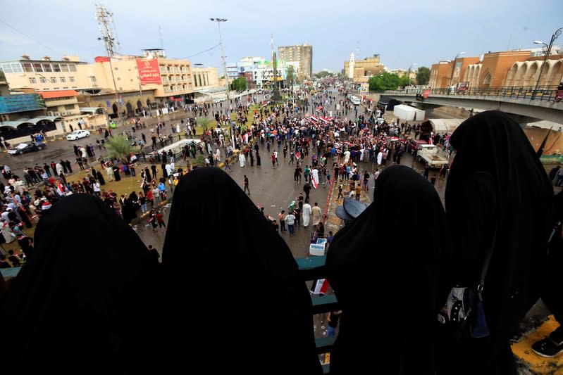 Demonstrators hold the Iraqi flag as they gather during a protest in Najaf