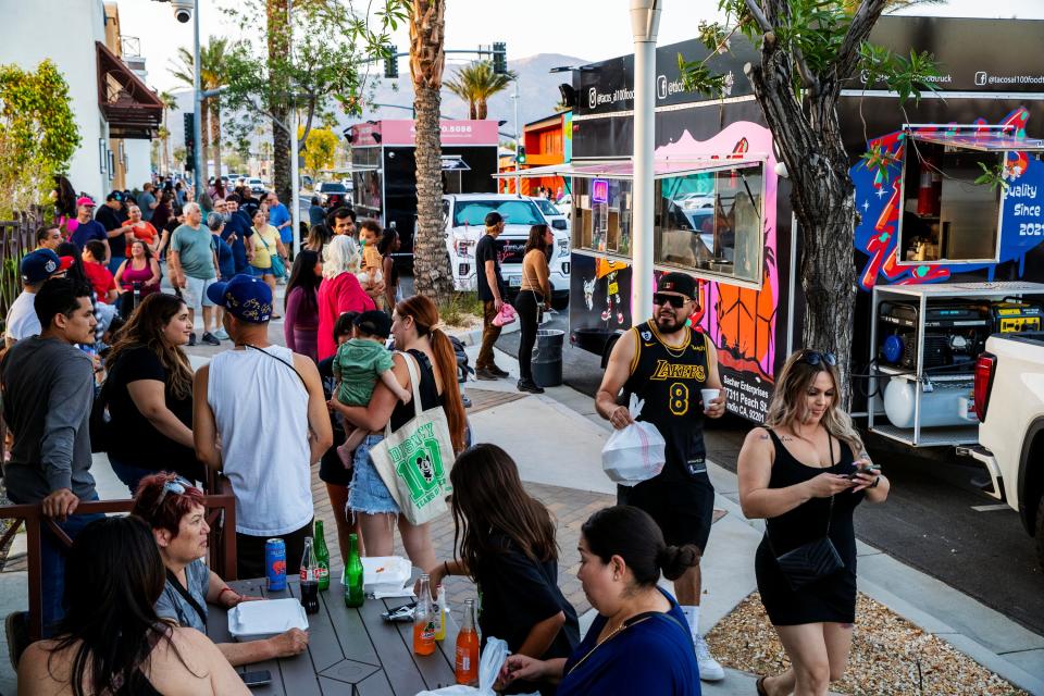 People gather to purchase food and beverages from various food trucks on Palm Drive and Pierson Boulevard for the first Friday Nights on Pierson event in Desert Hot Springs on May 12, 2023. The event continues March 8, 15, 22, and 29, 2024.