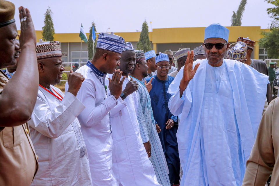 In this photo released by the Nigeria State House, Nigeria's incumbent President Muhammadu Buhari, of the All Progressives Congress party, right, greets supporters as he departs from Daura, Nigeria, bound for Abuja, following the postponement of presidential elections, Saturday, Feb. 16, 2019. Nigeria's presidential candidates on Saturday condemned the last -minute decision to delay the presidential election until Feb. 23. (Bayo Omoboriowo/Nigeria State House via AP)