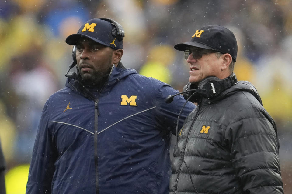 FILE - Michigan offensive coordinator Sherrone Moore, left, and coach Jim Harbaugh watch the team's play against Indiana during an NCAA college football game in Ann Arbor, Mich., Oct. 14, 2023. Michigan hired Moore on Friday, Jan. 26, 2024, to replace Harbaugh, giving the 37-year-old offensive coordinator an opportunity to lead college football's winningest program. The school made the move two days after Harbaugh bolted to lead the Los Angeles Chargers. (AP Photo/Paul Sancya)