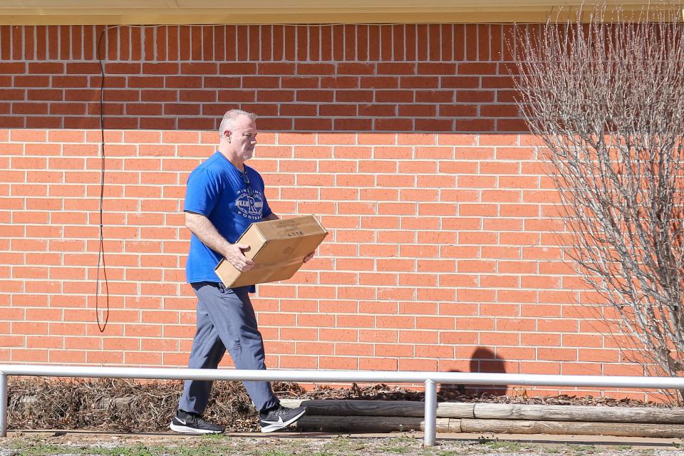 Philip Koons, the Ringling High School football coach and principal, walks out of the Ringling Public Schools superintendent's office to his truck with a box on Wednesday in Ringling.