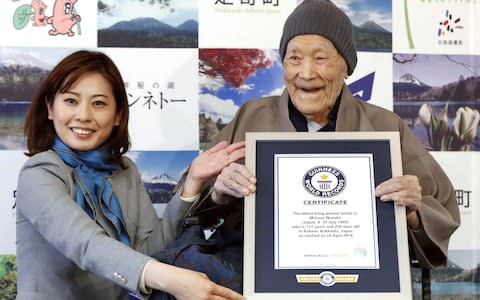Japanese Masazo Nonaka receives a Guinness World Records certificate naming him the world's oldest man  - Credit: Reuters