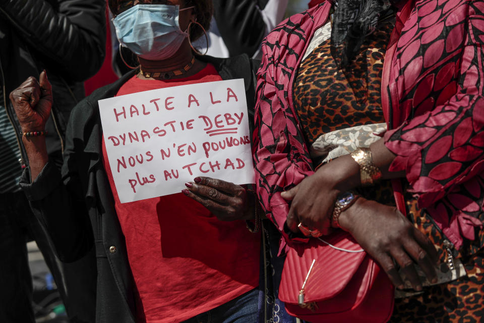 Chadian woman leaving in France holds a placard that reads, "stop to the Debt dynasty we can't take it anymore," during a protest in Paris, Sunday, April 25, 2021. Chadian activists and supporters of the "Front for Change and Concord" in Chad staged a protest in Paris on Sunday, following the death of the President Idriss Deby Itno. They denounce the nomination of Deby's son to assume the interim presidency, which they decry as "monarchization." (AP Photo/Lewis Joly)