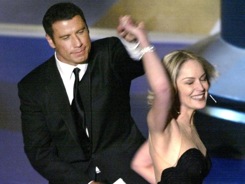 John Travolta (L) and Sharon Stone dance together during the 74th annual Academy Awards in Hollywood March 24, 2002. The two actors presented the Oscar for Best Foreign Film, which went to the film "No Man's Land". REUTERS/Gary Hershorn