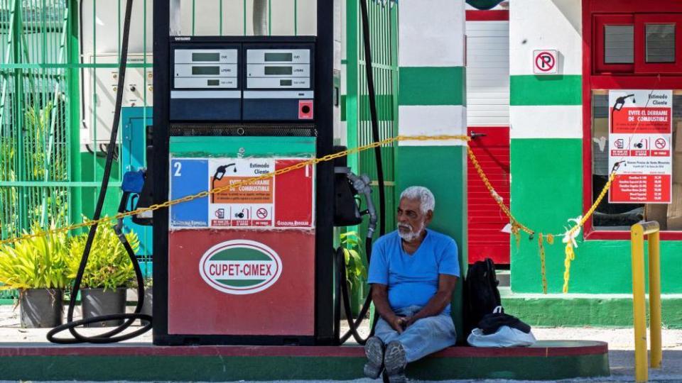 Un hombre sentado en una estación de gasolina en La Habana.