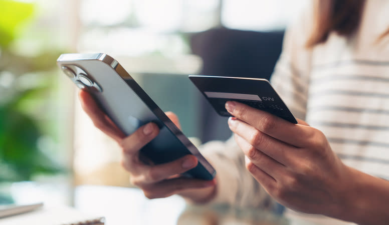 hands holding a phone and credit card