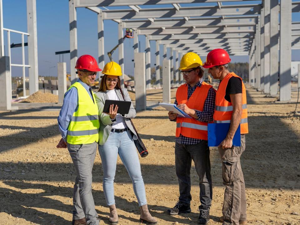 Construction project manager and construction workers at a construction site