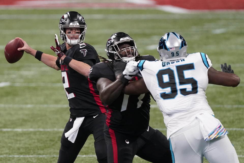 Atlanta Falcons quarterback Matt Ryan (2) works under pressure from Carolina Panthers defensive tackle Derrick Brown (95) during the first half of an NFL football game, Sunday, Oct. 11, 2020, in Atlanta. (AP Photo/John Bazemore)