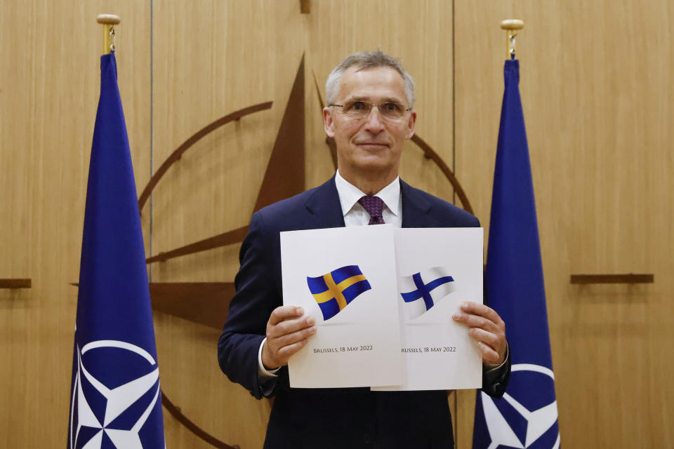 FILE - NATO Secretary-General Jens Stoltenberg displays documents as Sweden and Finland applied for membership in Brussels, Belgium, May 18, 2022. Delegations from Sweden and Finland were expected in Ankara, Turkey, for talks with Turkish officials on Wednesday, May 25, 2022, to try and overcome Turkey's objections to their NATO bids. (Johanna Geron, Pool via AP, file)