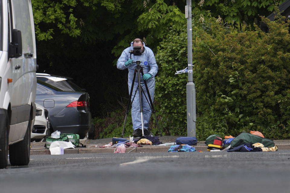 A police forensics officer inspects the scene of an attack in Hainault, north east London, Tuesday April 30, 2024. A man wielding a sword attacked members of the public and police officers in a east London suburb, killing a 13-year-old boy and injuring four others, authorities said Tuesday. The man was arrested at the scene, police said. Chief Supt. Stuart Bell said the incident is not being treated as terror-related or a “targeted attack.” (Jordan Pettitt/PA via AP)