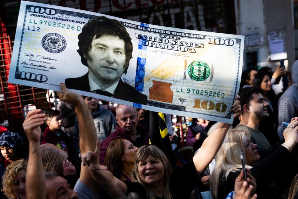 A supporter of Presidential candidate Javier Milei of La Libertad Avanza holds a replica of a hundred dollars bill with Milei's photo during a rally on September 25, 2023 in San Martin, Buenos Aires, Argentina.