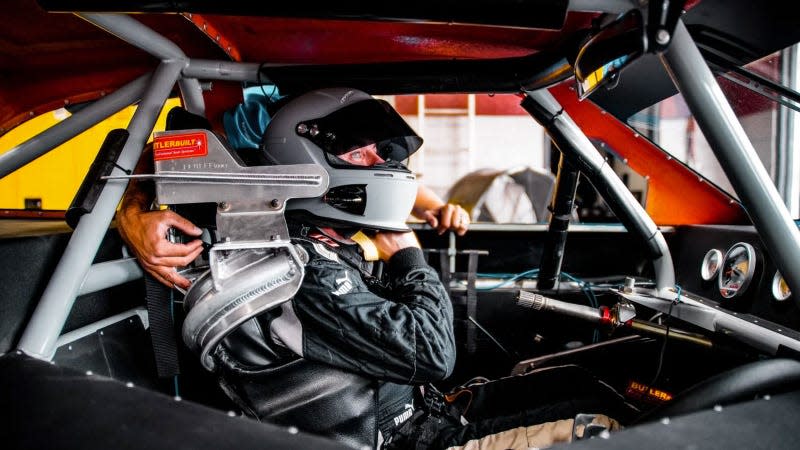 A photo of Frankie Muniz in the driving seat of a race car. 
