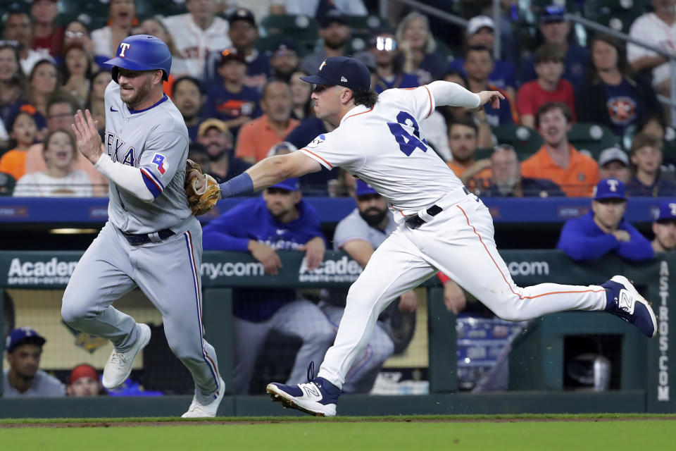 Texas Rangers' Travis Grossman, left, is tagged out by Houston Astros third baseman Alex Bregman during the third inning of a baseball game Saturday, April 15, 2023, in Houston. (AP Photo/Michael Wyke)