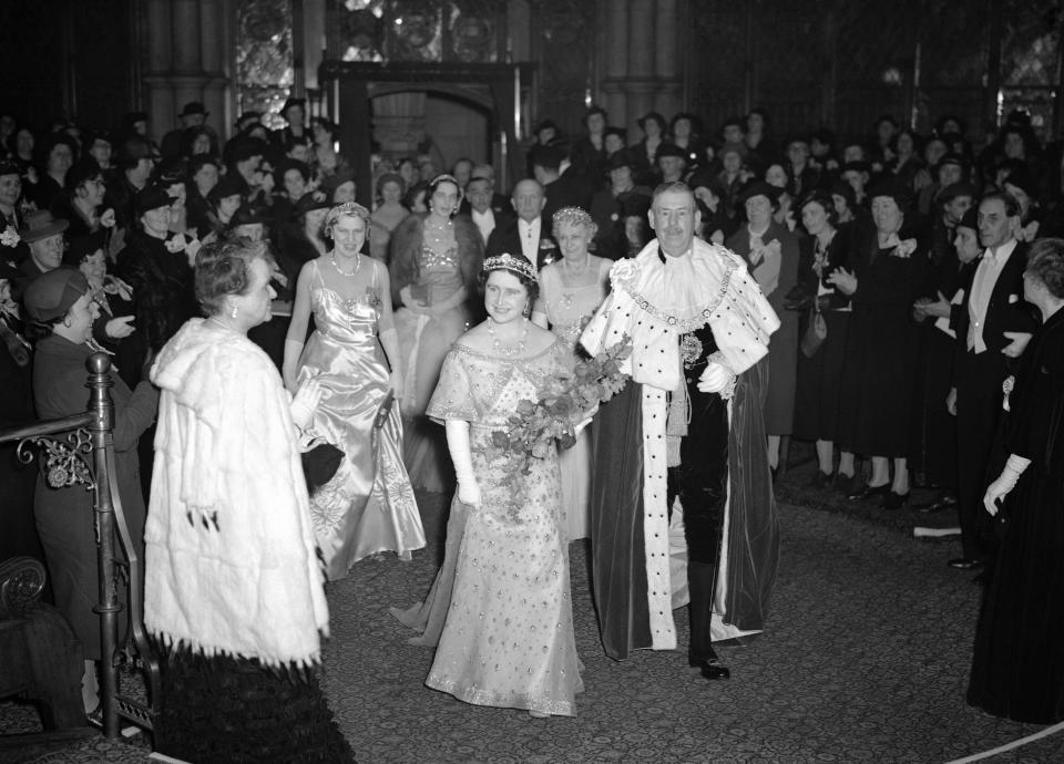 FILE - In this March 28, 1939 file photo, Britain's Queen Elizabeth with the Lord Mayor of London passes through the Council Chamber of the Guildhall to attend a party and reception in aid of the National Birthday Trust Fund in the Guildhall, London, after receiving purses from debutantes and peeresses. Prince Philip was the longest serving royal consort in British history. In Britain, the husband or wife of the monarch is known as consort, a position that carries immense prestige but has no constitutional role. The wife of King George VI, who outlived him by 50 years, was loved as the Queen Mother. (AP Photo/Leslie Priest, File)