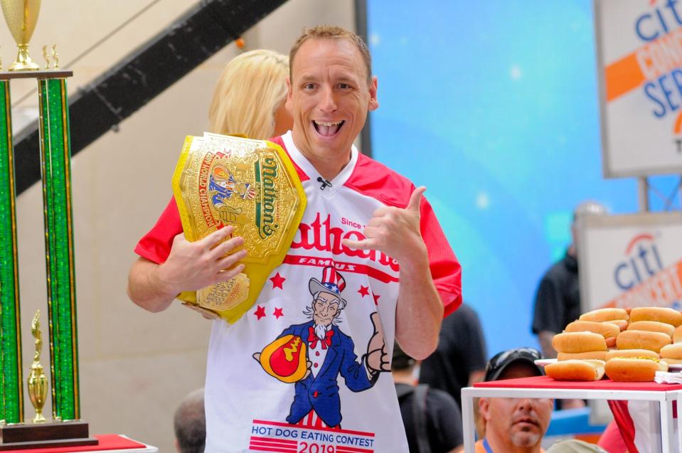 Joey Chestnut with hot dog eating champion belt