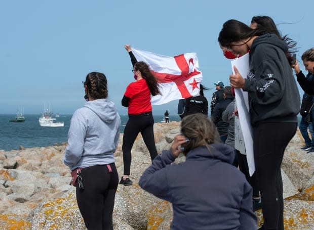 A supporter of Sipekne'katik holds a Mi'kmaw flag at the Saulnierville wharf in the fall.