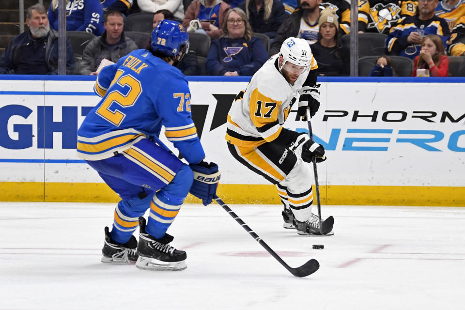 Pittsburgh Penguins right wing Bryan Rust (17) controls the puck as St. Louis Blues defenseman Justin Faulk (72) skates in during the third period of an NHL hockey game, Saturday, Feb. 25, 2023, in St. Louis. (AP Photo/Jeff Le)