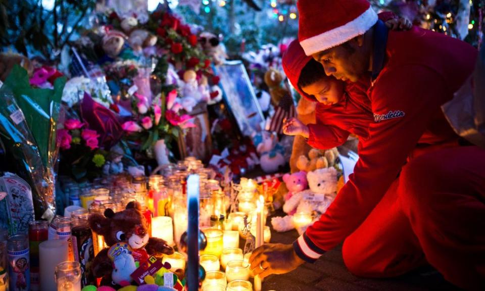 A mourner lights a candle for those who died at Sandy Hook Elementary School in December 2012.