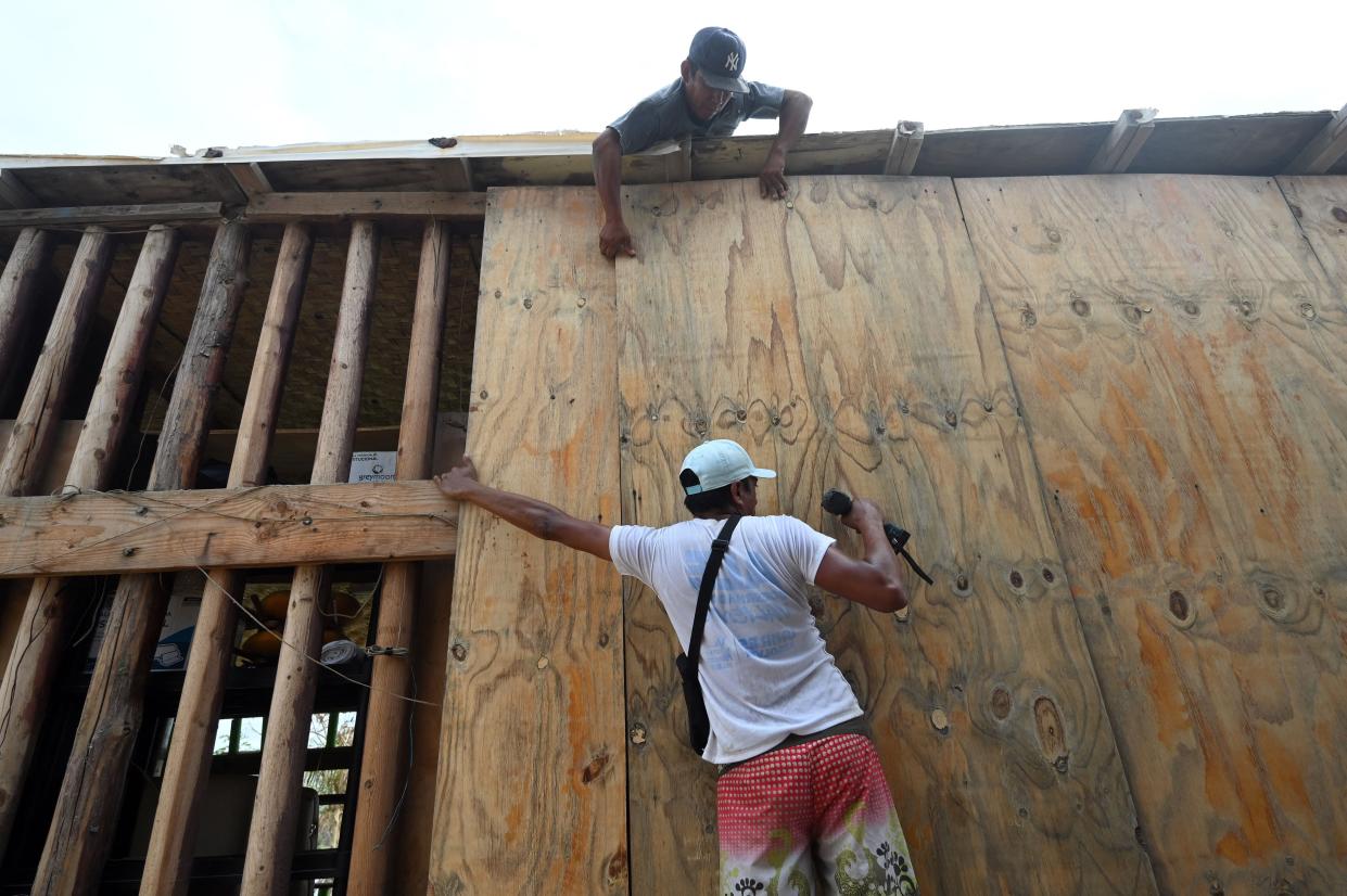 Restaurant employees put protective wood planks at a restaurant near the beach before the arrival of Hurricane Hilary at Los Cabos resort in Baja California state, Mexico on August 18, 2023. (AFP via Getty Images)