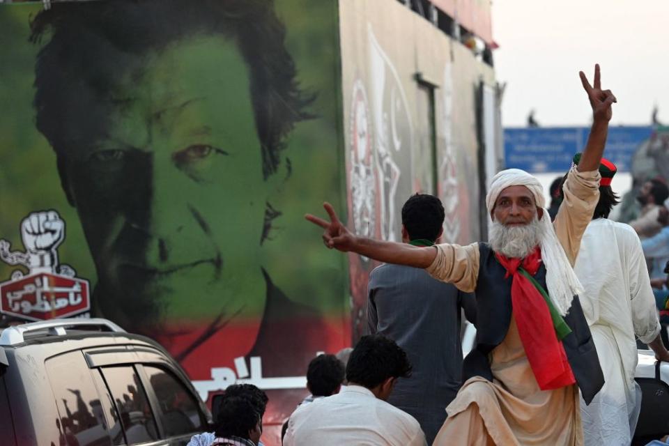 A supporter of ousted Pakistan's prime minister Imran Khan flashes the victory sign as they march along a street during a demonstration in Islamabad on May 26, 2022.<span class="copyright">AAMIR QURESHI/AFP via Getty Images</span>