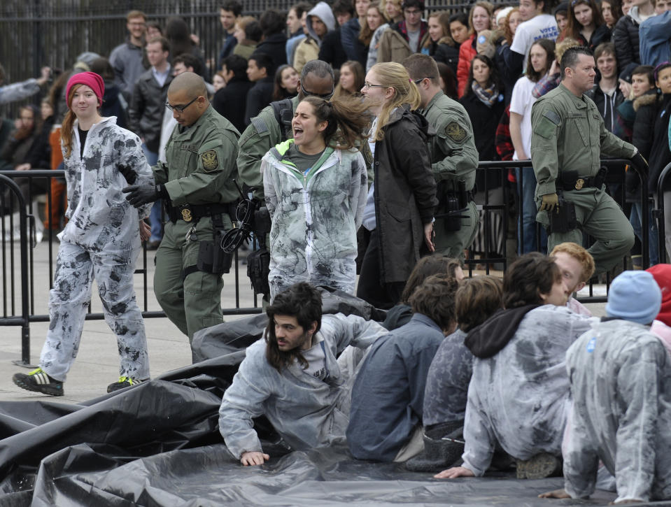 Several hundred students and youth who marched from Georgetown University to the White House to protest the Keystone XL Pipeline are arrested outside the White House in Washington, Sunday, March 2, 2014. (AP Photo/Susan Walsh)