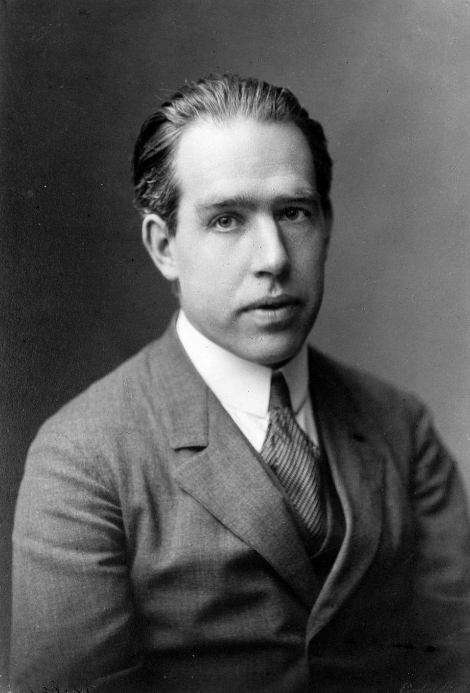 neils bohr looks at the camera, he wears a suit jacket, collared shirt and tie