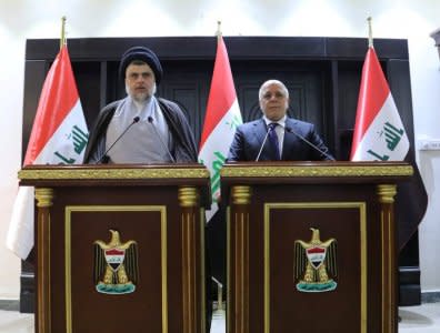 Iraqi Shi'ite cleric Moqtada al-Sadr (L) speaks during a news conference with Iraqi prime Minister Haider al-Abadi in Baghdad, Iraq May 20, 2018. Iraqi Prime Minister Media Office/Handout via REUTERS