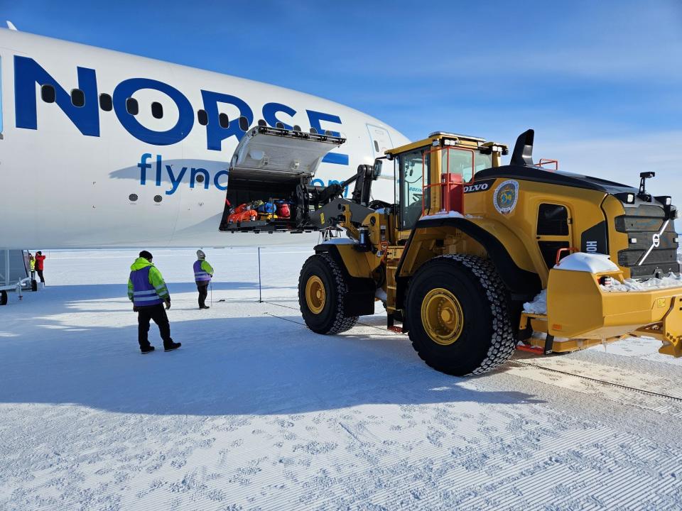 The Norse 787 in Antarctica next to a snow tractor unloading the cargo bay.