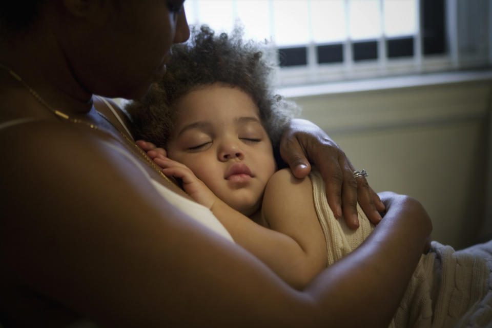 kid asleep in mother's arms