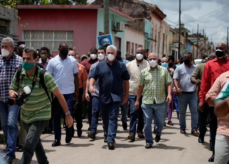 Cuba's President Miguel Diaz-Canel walks with others, in San Antonio de los Banos