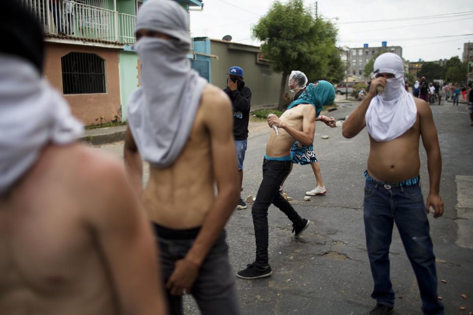 Un manifestante lanza una roca a la policía, en un enfrentamiento durante la protesta contra el gobierno de Nicolás Maduro, en Valencia Venezuela, el miércoles 26 de febrero de 2014. Las protestas iniciaron con estudiantes en distintas ciudades, quienes están molestos por el crimen, los problemas económicos y la mano dura con la que la policía les ha respondido. (AP Photo/Rodrigo Abd)