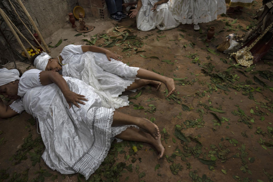 Women, who practice the Afro Brazilian faith Candomble, perform a ritual honoring Obaluae, the deity of earth and health, at their temple on the outskirts of Salvador, Brazil, Saturday, Sept. 17, 2022. (AP Photo/Rodrigo Abd)