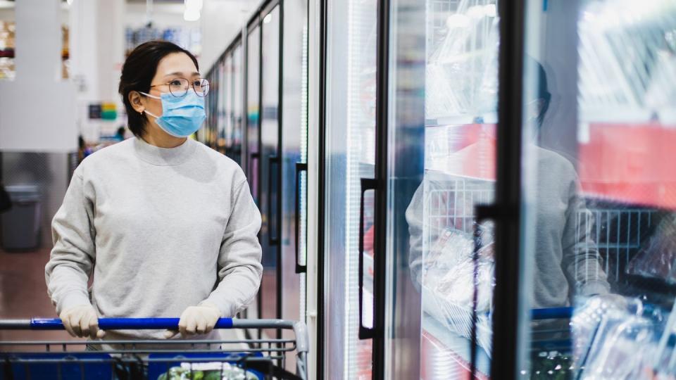 asian female wearing a face mask shopping at the supermarket