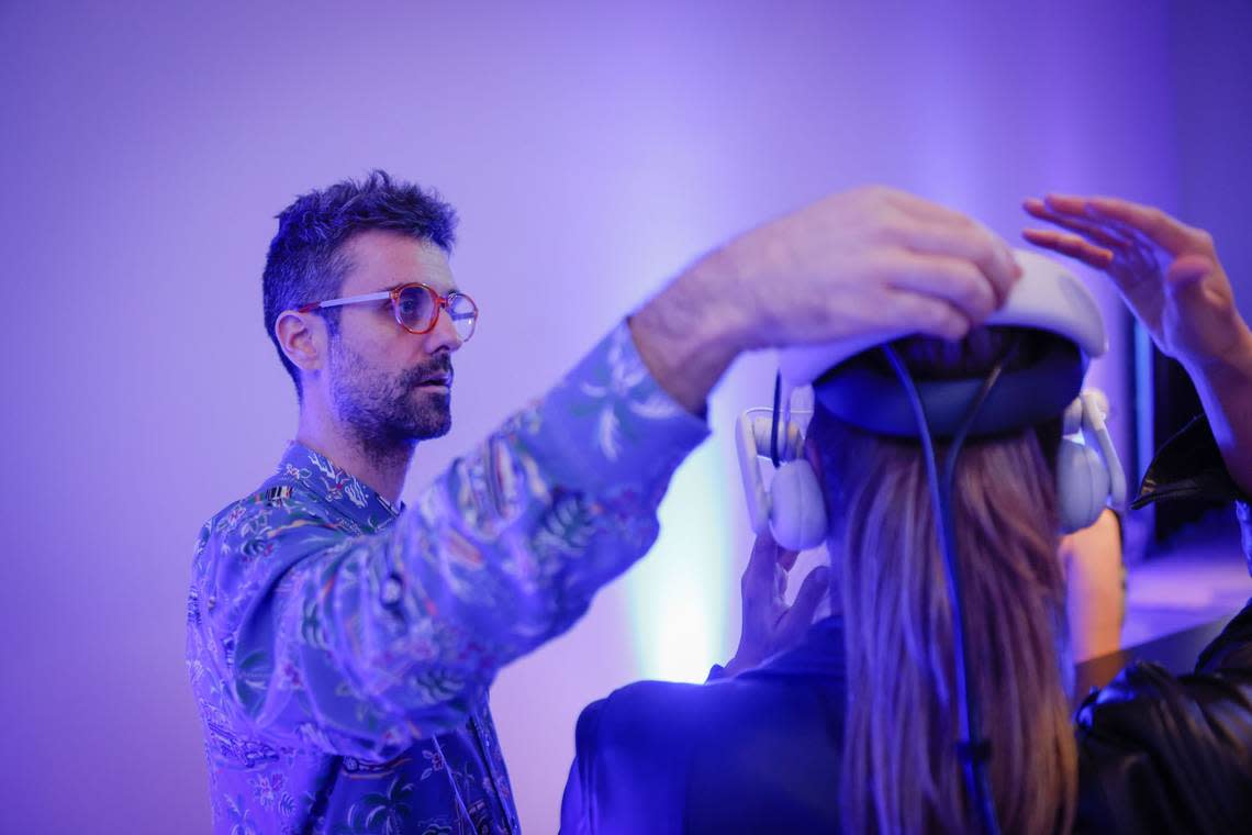 Mattia Casalegno, who was inspired to create “Aerobanquets RMX” by a 1932 futuristic cookbook, helps a guest with her VR headset.