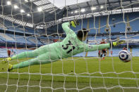 Manchester United's Bruno Fernandes, center right, scores the opening goal from the penalty spot past Manchester City's goalkeeper Ederson during the English Premier League soccer match between Manchester City and Manchester United at the Etihad Stadium in Manchester, England, Sunday, March 7, 2021. (Peter Powell/Pool via AP)