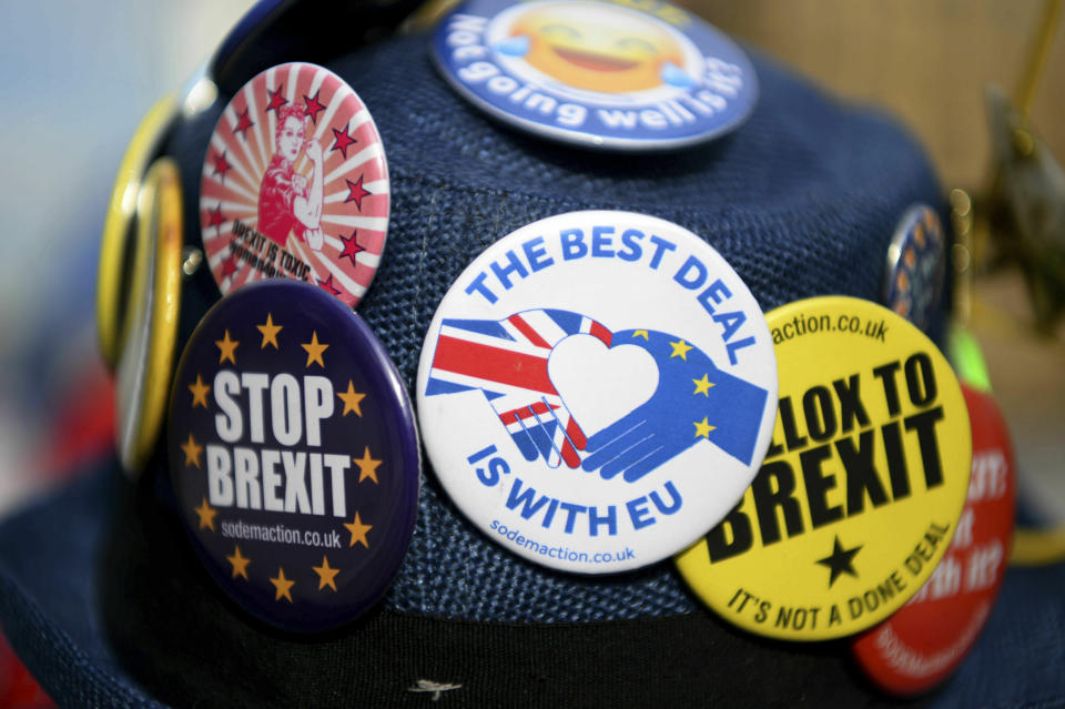 Detail of badges on an anti-Brexit protestor's hat during protests outside Britain's parliament in London, Wednesday Feb. 13, 2019. British Prime Minister Theresa May urged lawmakers this week to give her more time to rework the Brexit agreement with the EU, with time ticking down to the March 29 deadline for a Brexit split from Europe. (Kirsty O'Connor/PA via AP)