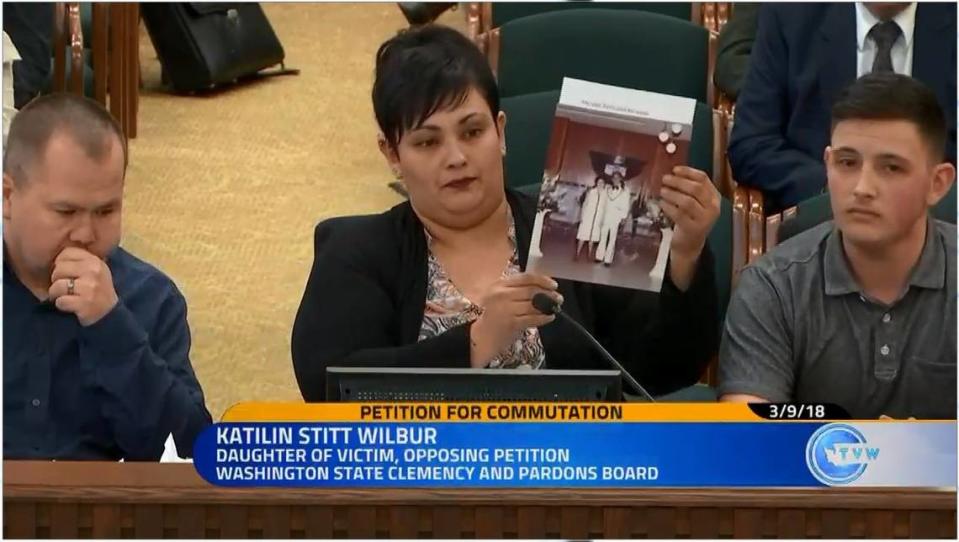 Katilin Stitt Wilbur holds up a photo of her father, Terry Lynn Stitt, and her grandmother during a state Clemency & Pardons Board hearing for David John Lennon in Olympia in 2018.