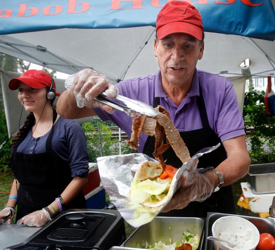 Mohamed Ghobashi of the Kabob House makes a lamb gyro sandwich for a customer, with the help of his daughter, Sally, at the Ashland Farmers Market, June 10, 2021. Ghobashi has been participating in the Ashland Farmers' Market for 10 years.