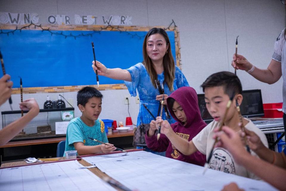 Instructor Fei Fei Xie teaches students on Tuesday, July 11, 2023, how to hold their brush as they write Chinese characters during a summer program at William Land Elementary in Southside Park. The school’s Mandarin immersion program is one of seven dual language immersion programs in the Sacramento City Unified School District.