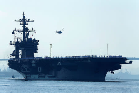 FILE PHOTO - Sailors man the rails of the USS Carl Vinson, a Nimitz-class aircraft carrier, as it departs its home port in San Diego, California August 22, 2014. REUTERS/Mike Blake/File Photo