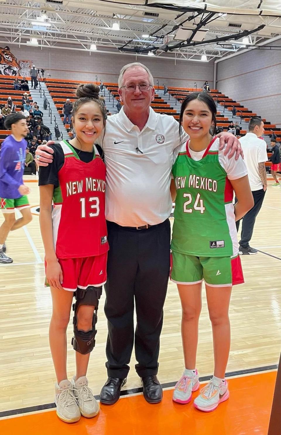 Farmington High's Kamalani Anitielu (13) and Tinaya Parrish (24) represent their respective teams along with Farmington girls basketball head coach Tom Adair in the New Mexico High School Coaches Association's Class 5A All-Star Game, Saturday, March 18, 2023 at Gallup High School.