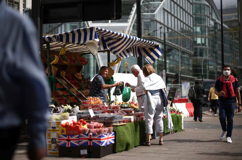 A person buys produce from a fruit and vegetable market stall in central London