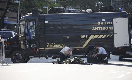 Bomb squad agents control the area near the finishing line of the men's cycling road race at the 2016 Rio Olympics after they made a controlled explosion, in Copacabana, Rio de Janeiro, Brazil August 6, 2016. REUTERS/Eric Gaillard