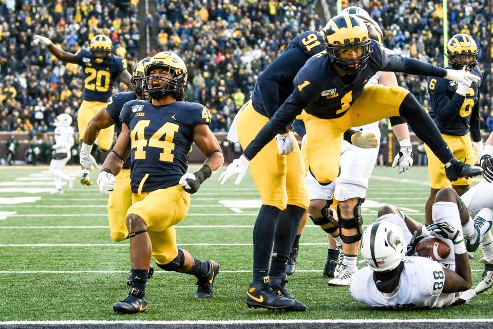 Michigan defenders, including Cameron McGrone, left, and Ambry Thomas, celebrate after stopping the Michigan State offense on a fourth down late in the game in November 2019 in Ann Arbor.