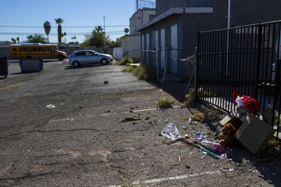 A school bus passes a damaged makeshift memorial for a high school student along an alleyway near Rancho High School in eastern Las Vegas, onTuesday, Nov. 21, 2023. Authorities have arrestedat least eight students in connection with the beating of Jonathan Lewis Jr., who died a week after a prearranged fight over a pair of headphones and a vape pen. (AP Photo/Ty O'Neil)