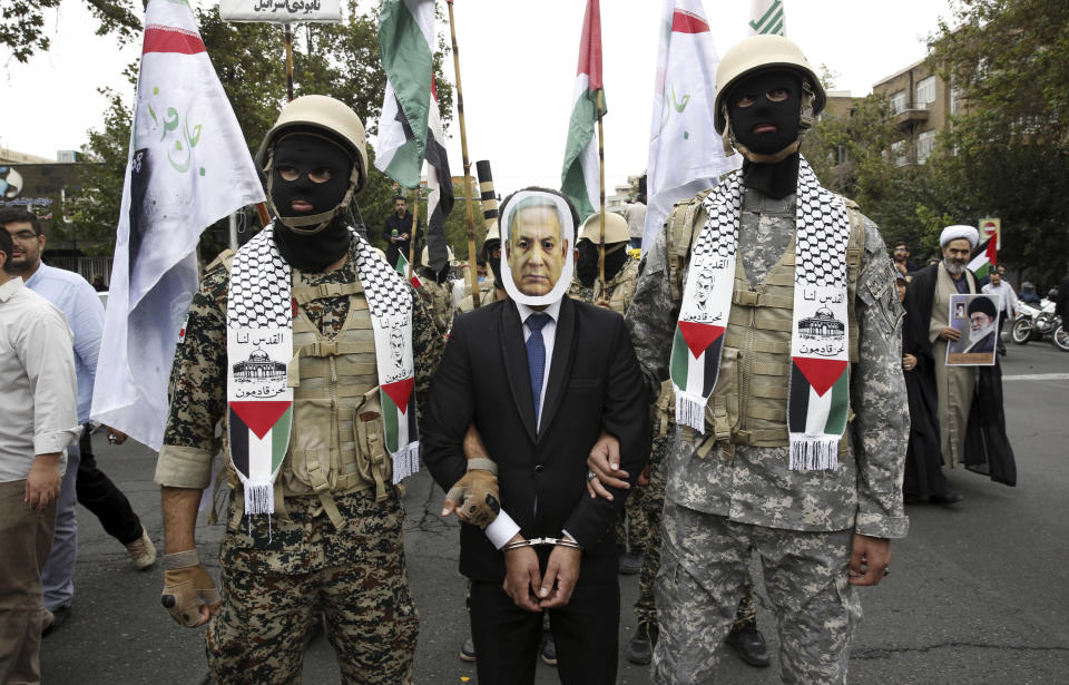 Iranian Basij paramilitary force members, in the style of the Palestinian and Lebanese militants, play the detention of the Israeli Prime Minister Benjamin Netanyahu during a pro-Palestinian rally after the Friday prayer in Tehran, Iran, Friday, Oct. 13, 2023. (AP Photo)