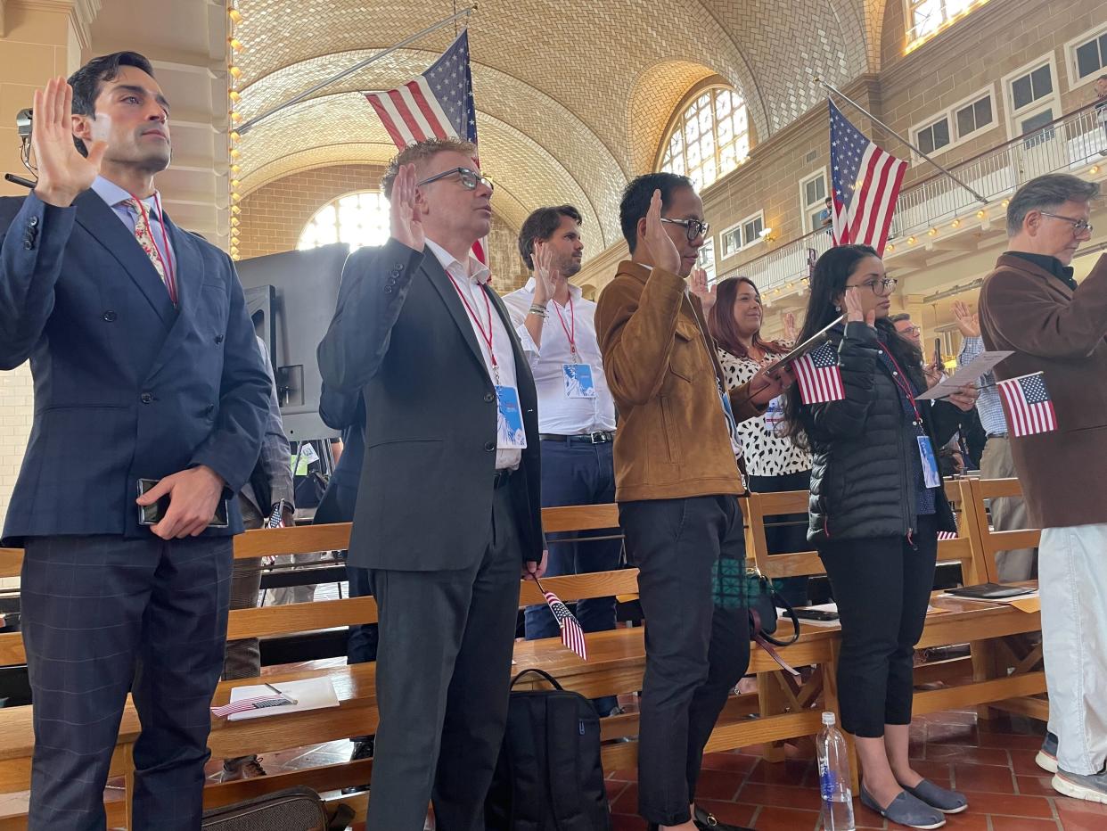 New U.S. citizens raise their hands to swear the oath.