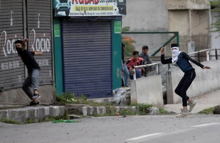 Kashmiri residents throw stones towards Indian security forces during restrictions after the scrapping of the special constitutional status for Kashmir by the government, in Srinagar