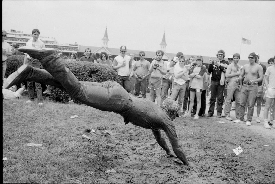 A young man dives in the mud on a rainy day during the 1984 Kentucky Derby.